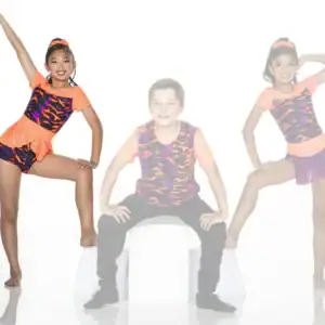 Three young dancers posing in colorful costumes against white background.