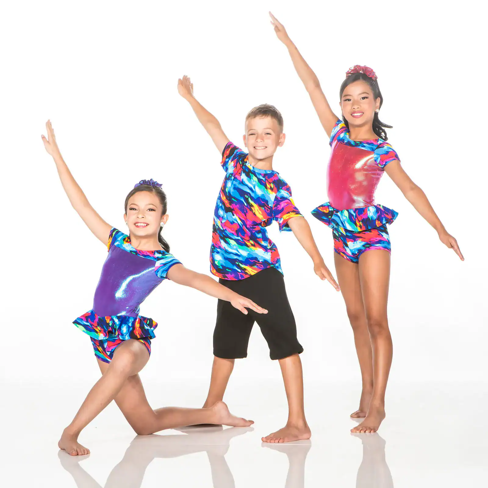 Three children posing in colorful dance costumes