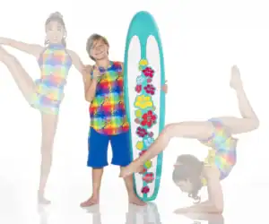 Children pose with floral surfboard in colorful swimwear