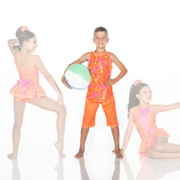 Three children modeling bright floral swimwear with beach ball