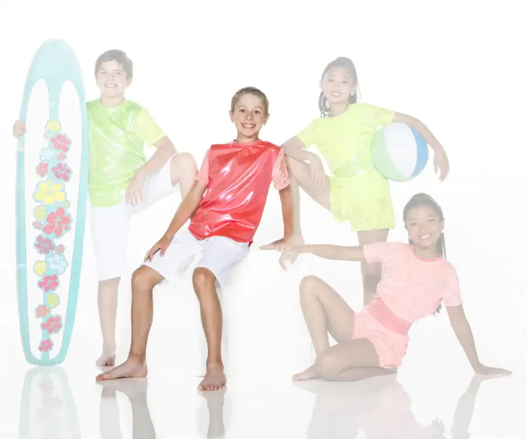 Four children in colorful beachwear pose with surfboard and ball.