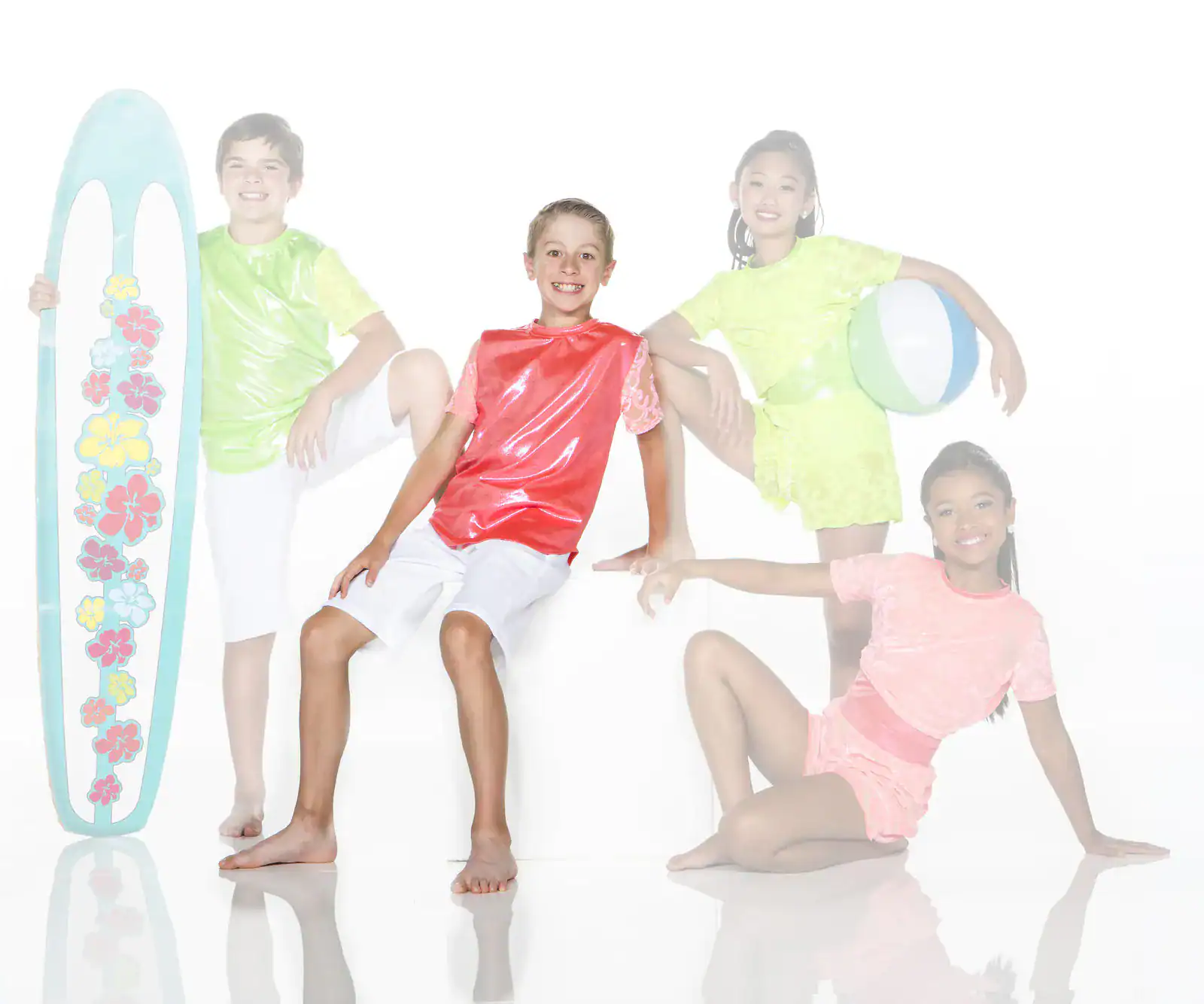 Four children in colorful beachwear pose with surfboard and ball.