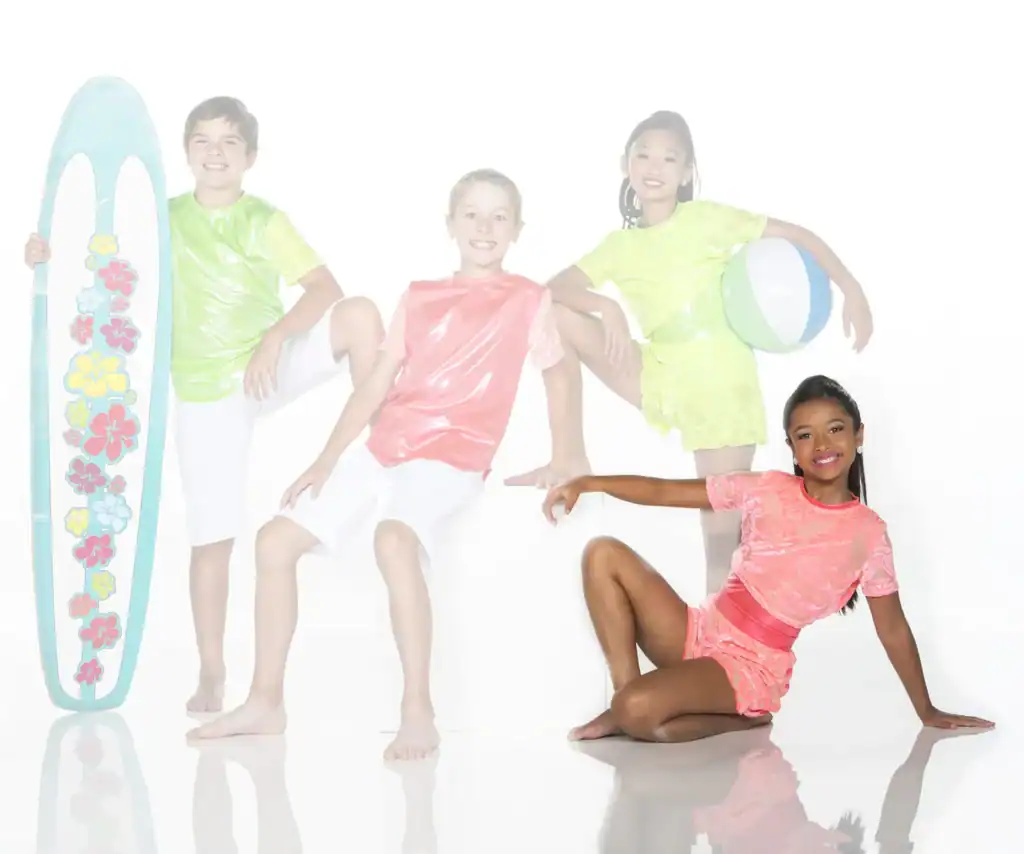 Children in colorful outfits pose with surfboard and beach ball