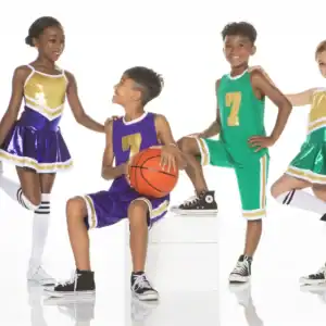 Children in basketball uniforms and cheerleading outfits posing together