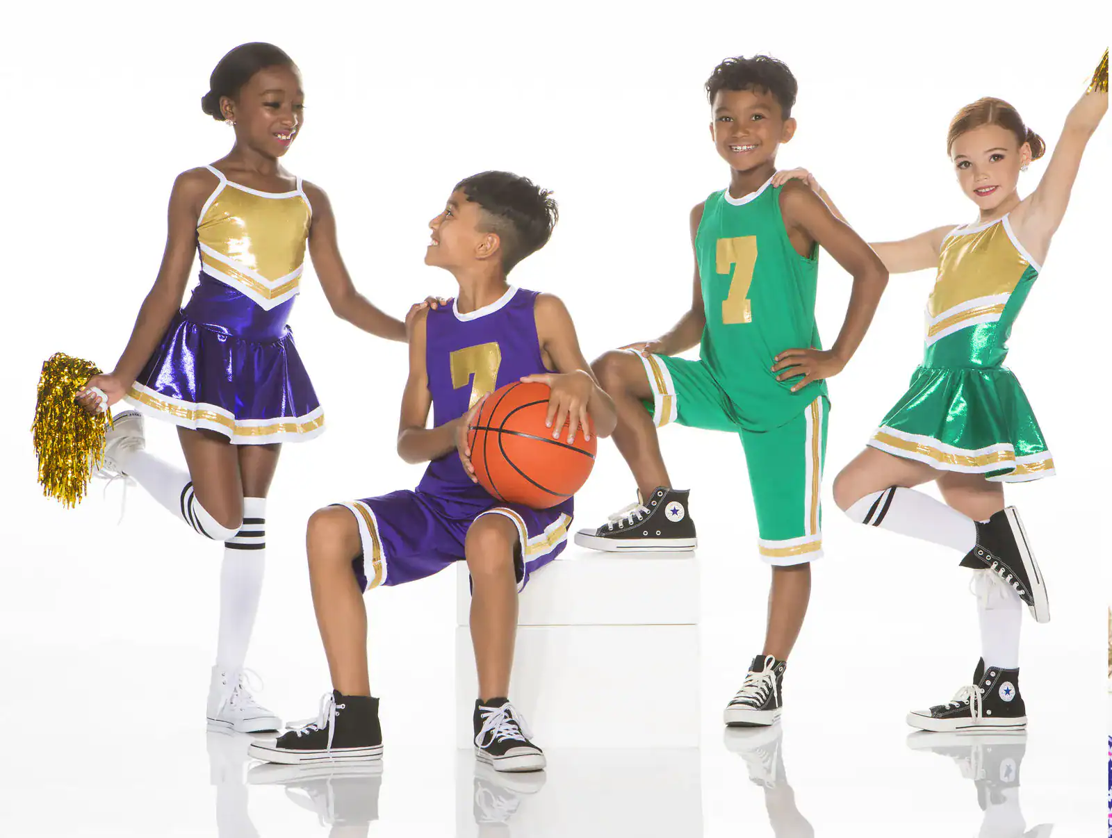 Children in basketball uniforms and cheerleading outfits posing together