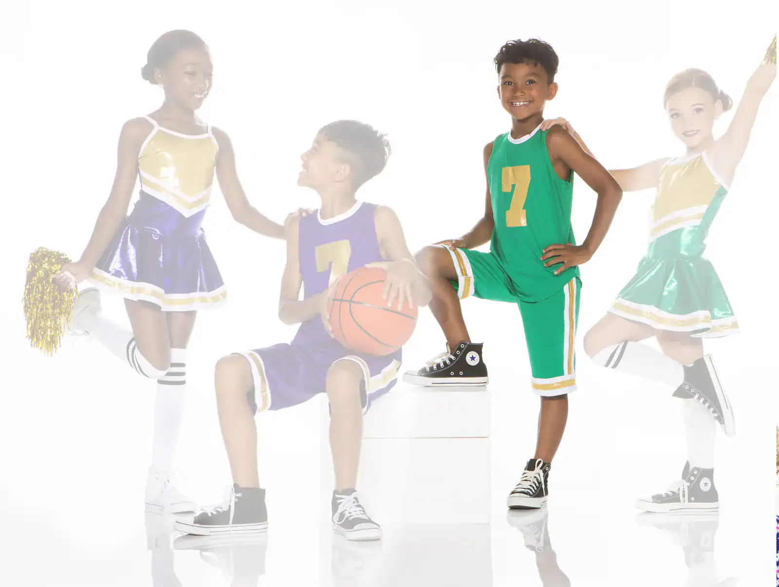 Children in basketball uniforms and cheerleading outfits posing together