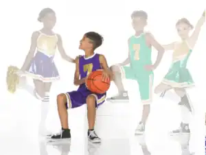 Children in basketball uniforms and cheerleading outfits pose together