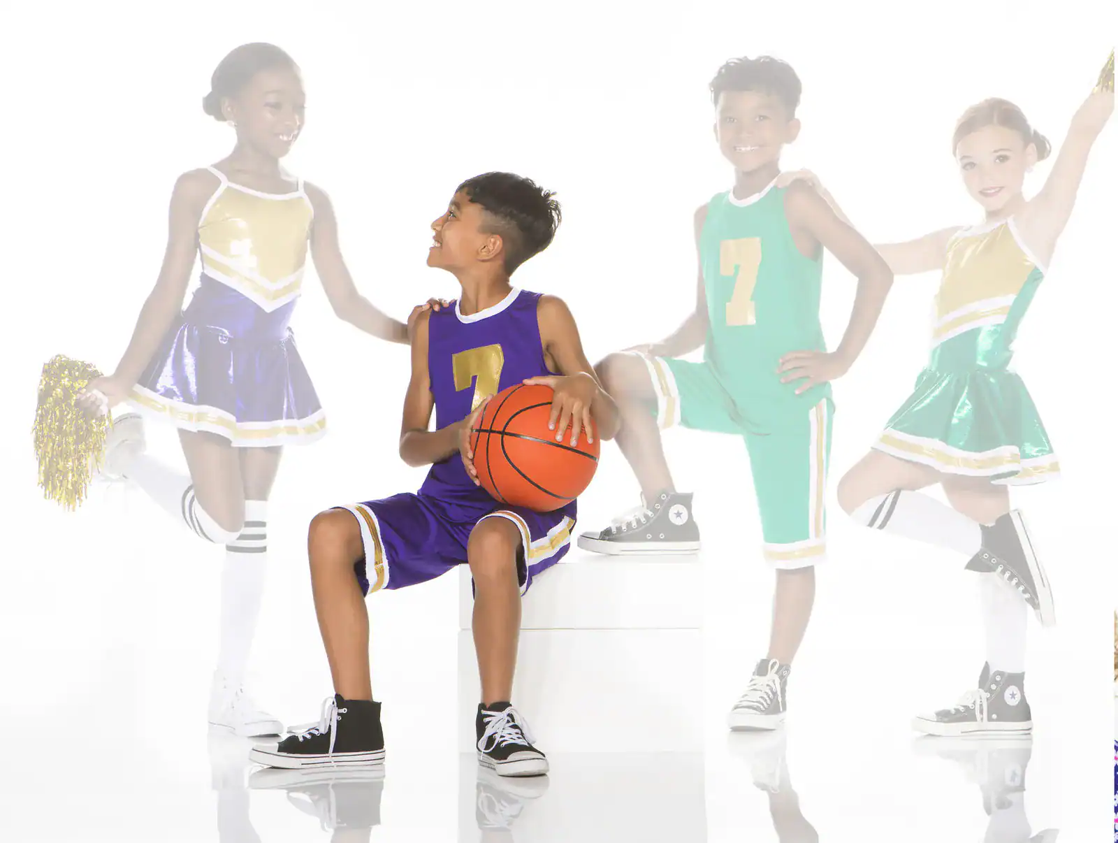 Children in basketball uniforms and cheerleading outfits pose together