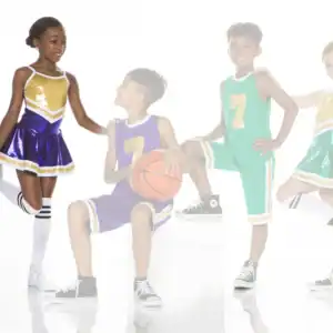 Four children in cheerleading and basketball uniforms posing together