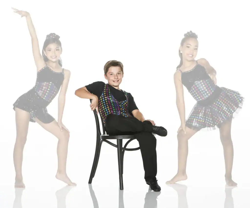 Three young dancers in colorful costumes posing in studio
