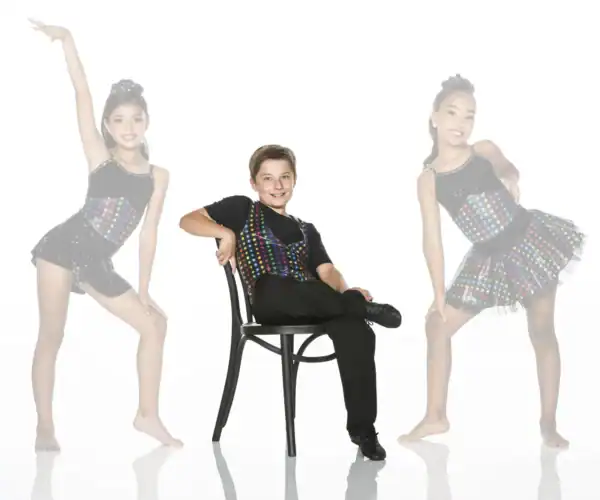 Three young dancers in colorful costumes posing in studio