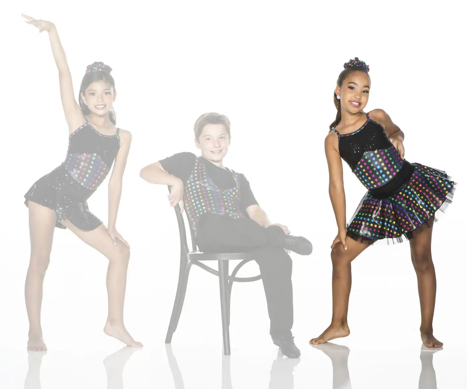 Three young dancers in colorful polka-dot costumes posing