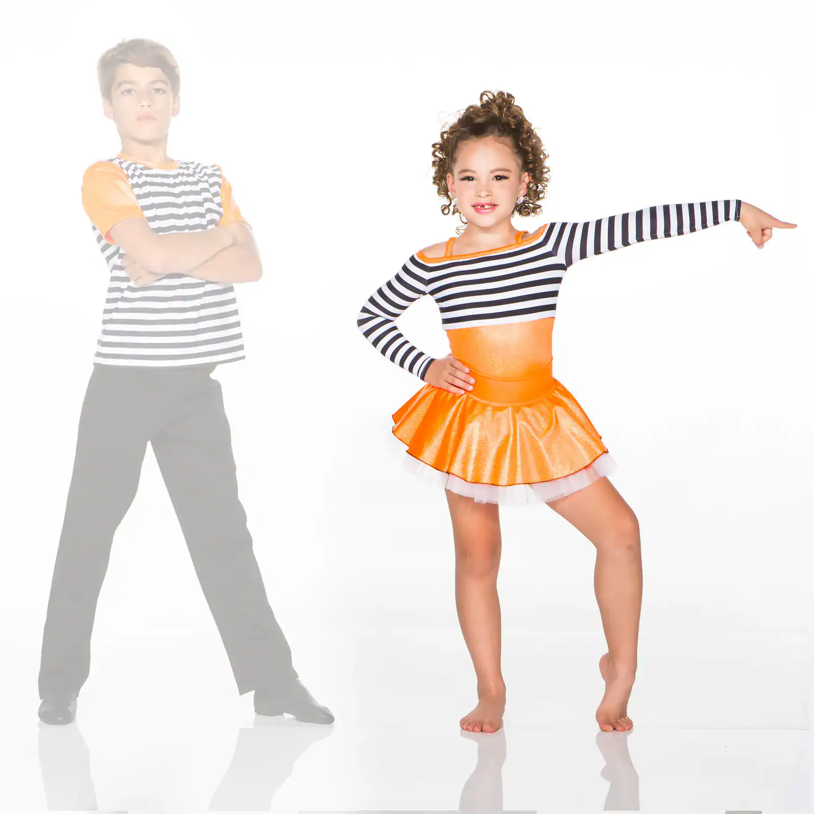 Girl in orange dance costume pointing beside boy