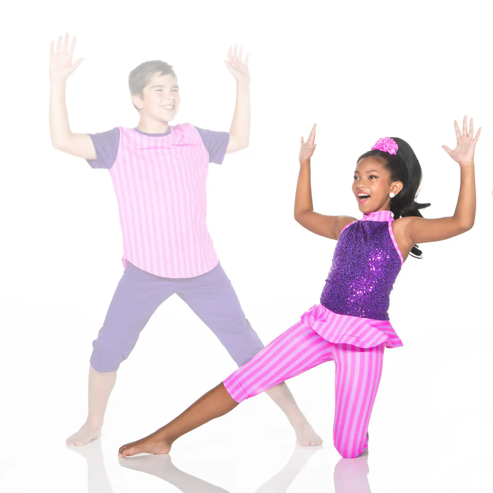 Two children dancing in colorful pink and purple costumes