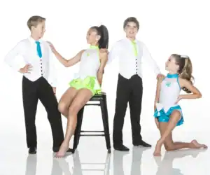 Four children wearing colorful dance costumes pose in studio.