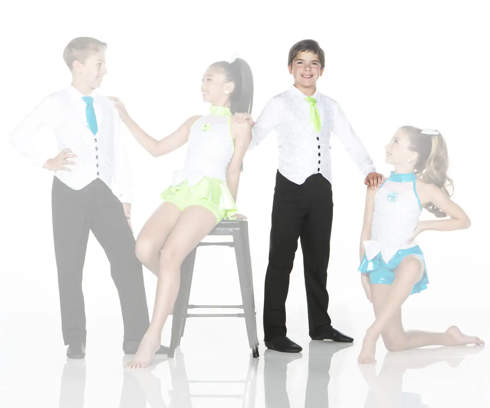 Four young dancers posing in colorful performance costumes