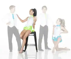 Young dancers in sparkling costumes pose against white background.