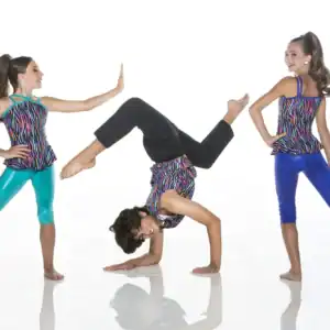 Three girls modeling colorful dancewear, one doing a handstand.
