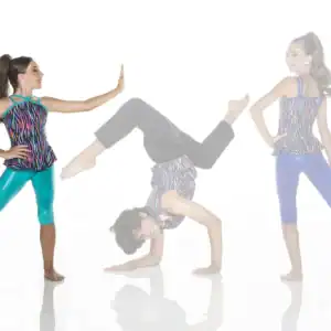 Three girls in colorful dancewear pose against a white background.