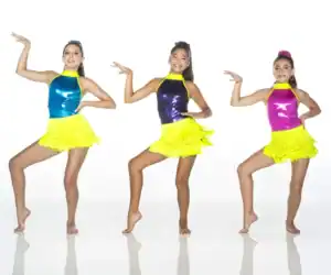 Three young dancers in colorful fringe costumes posing