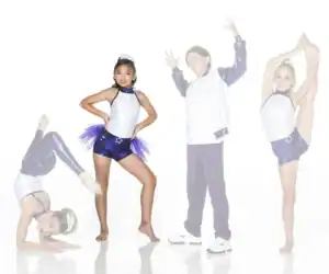 Four young dancers posing in purple and white costumes