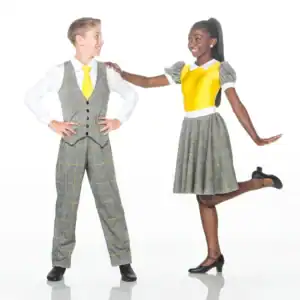 Two children smiling in coordinated yellow and plaid outfits