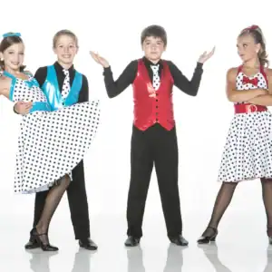Young dancers wearing colorful polka-dot costumes pose together