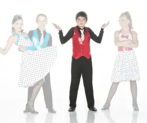 Four children in colorful polka-dot dance costumes posing