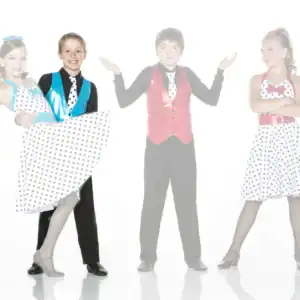 Young dancers in colorful polka-dot costumes posing on white background