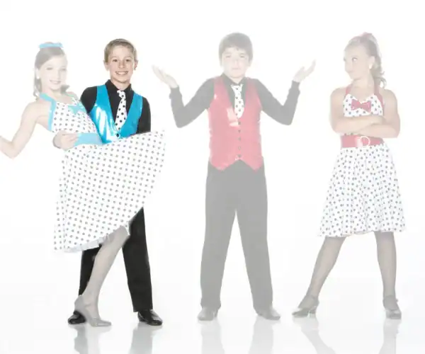 Young dancers in colorful polka-dot costumes posing on white background