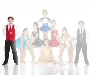 Young dancers in colorful costumes pose for a group photo.