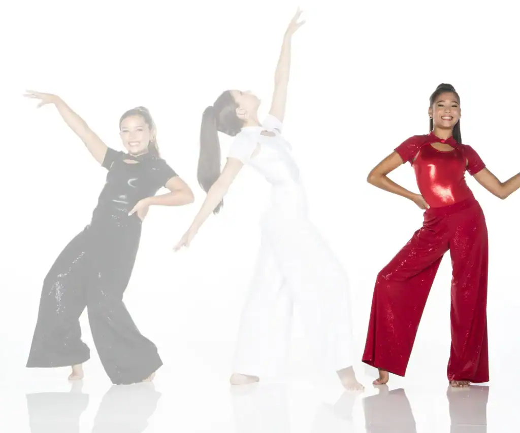 Three dancers pose in sparkling black, white, and red outfits.