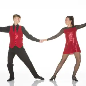 Two dancers in red sequins hold hands in pose.