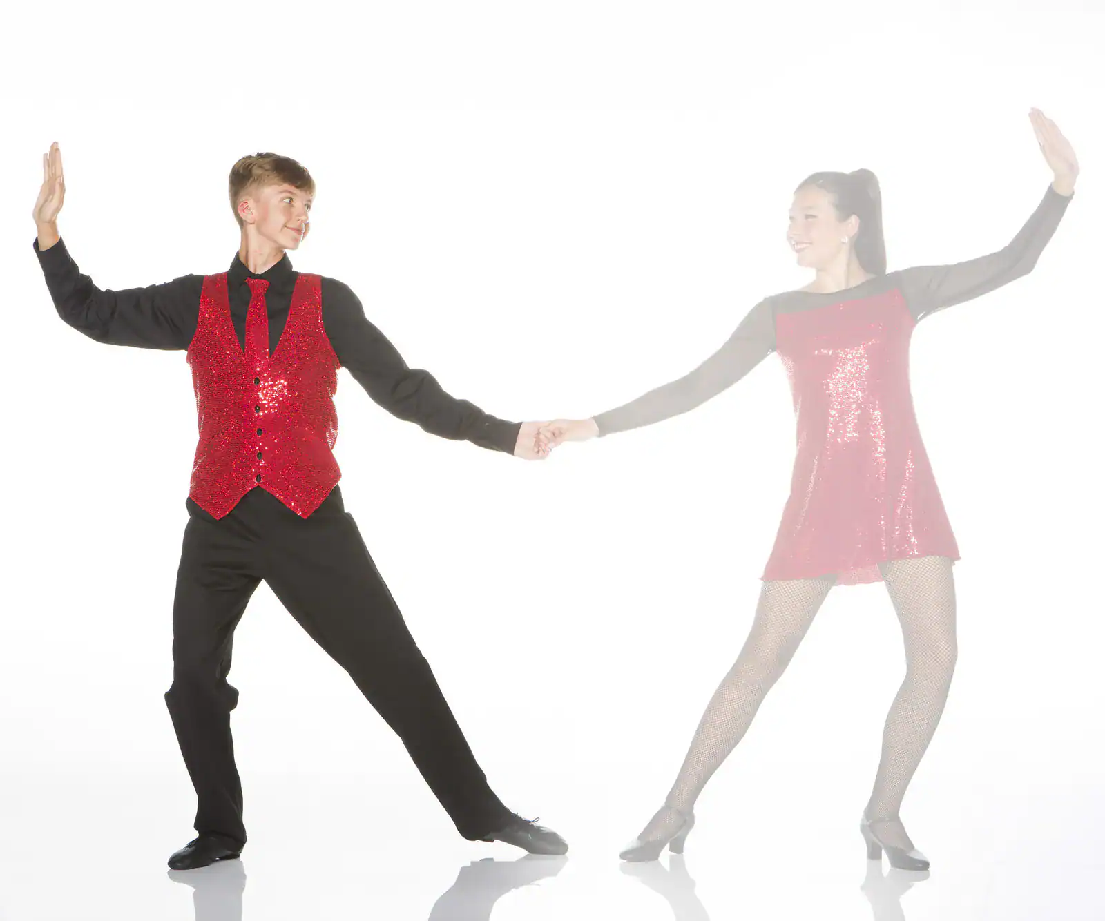 Two dancers in red costumes holding hands on white background