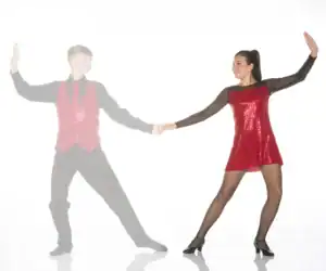 Dance partners holding hands in red sequined costumes