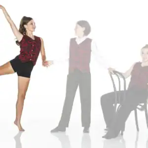 Three performers in coordinated red patterned costumes pose together.
