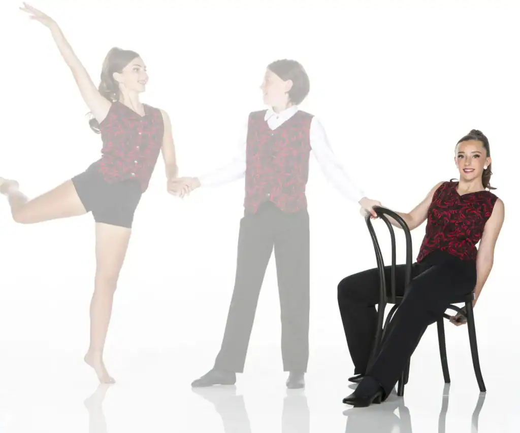 Three dancers wearing matching red patterned costumes pose together.