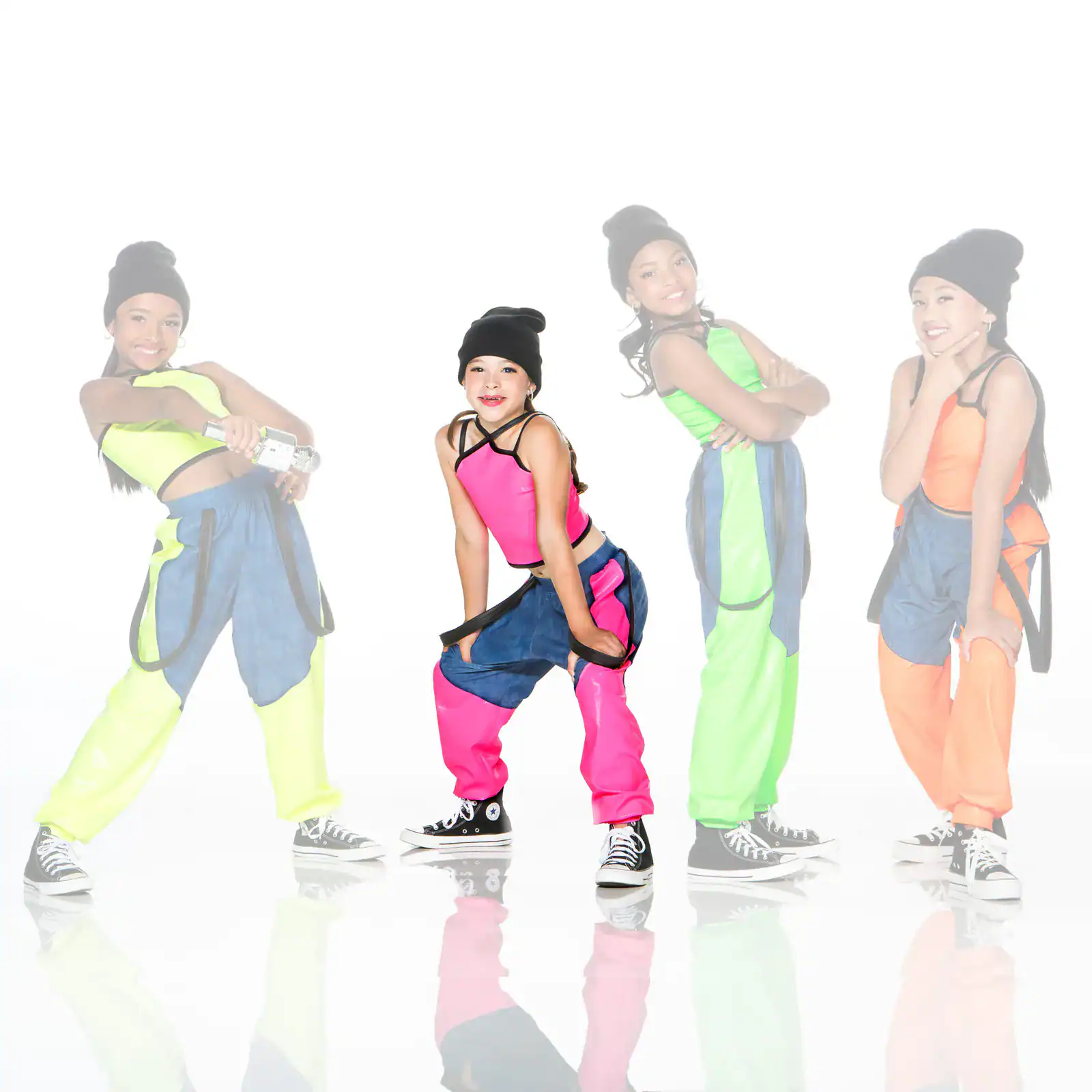 Four girls in colorful hip-hop outfits posing against white background