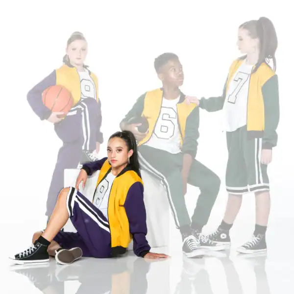 Four teens in varsity jackets pose with basketballs.