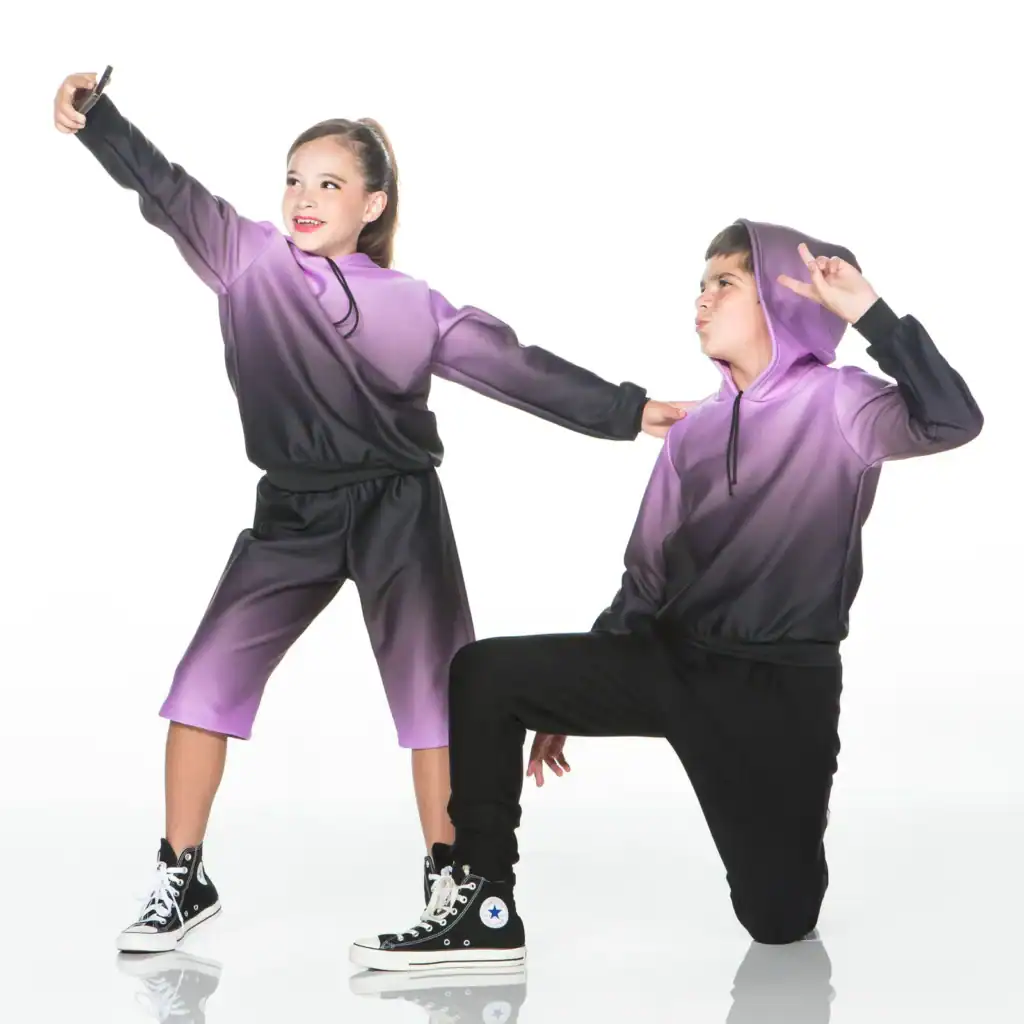 Two children pose in matching purple and black hoodies.