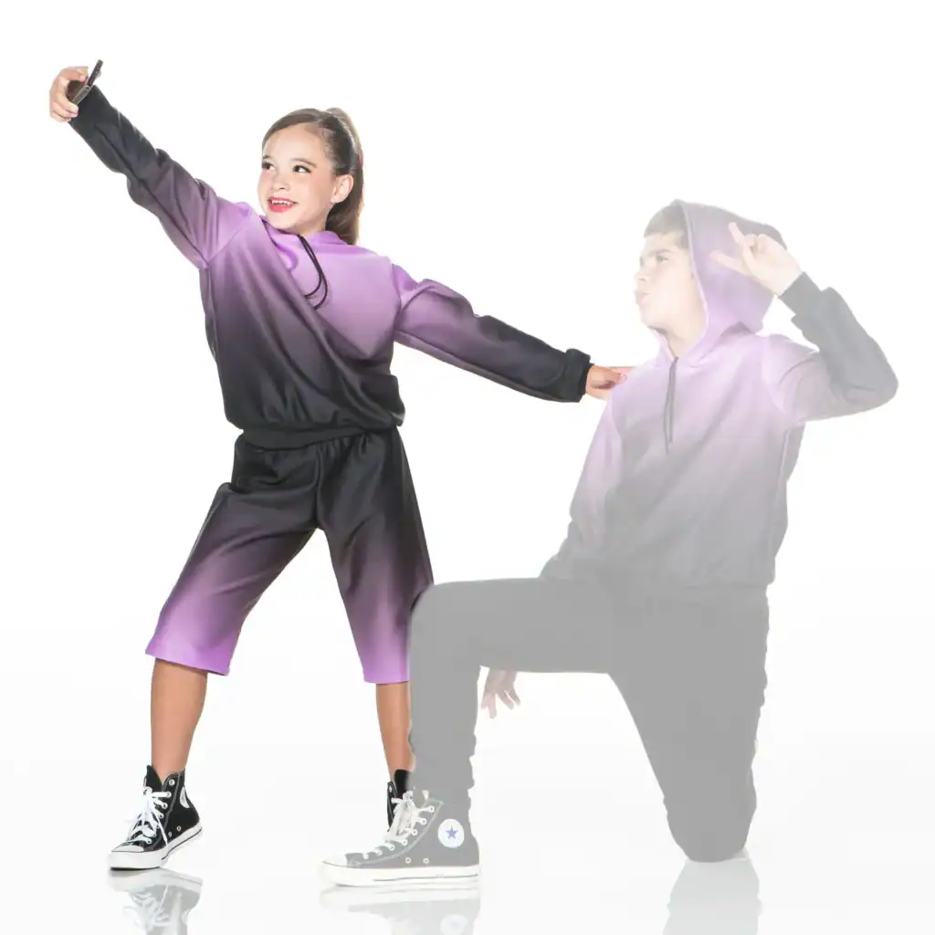 Girl in purple tracksuit takes selfie beside fading boy