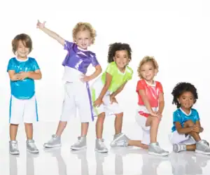 Five children wearing colorful dance outfits and silver sneakers