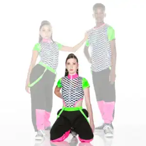 Three dancers in neon checkerboard outfits pose against white background.