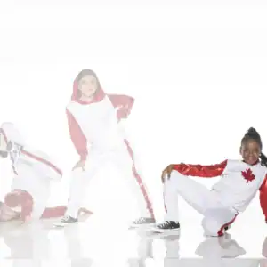 Three dancers in white and red Canadian-themed costumes posing.