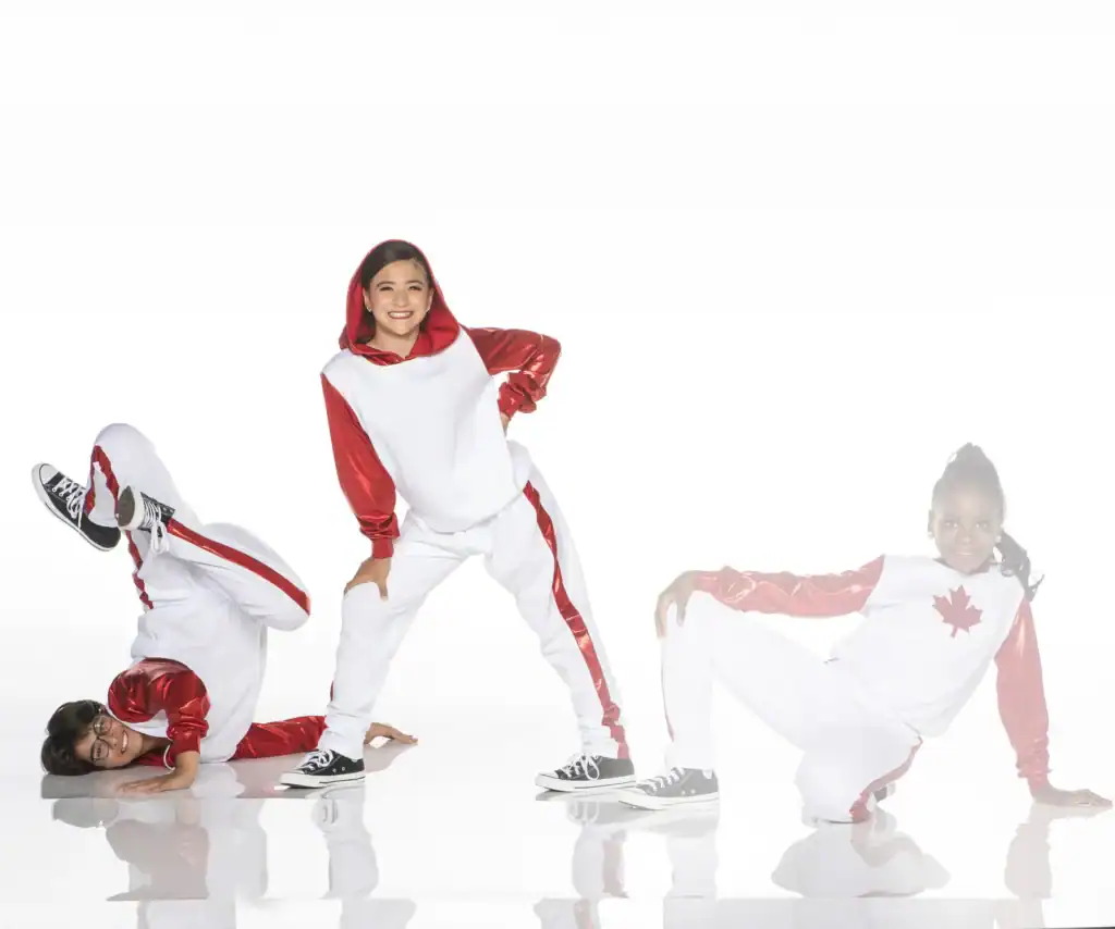 Three dancers in red and white costumes posing