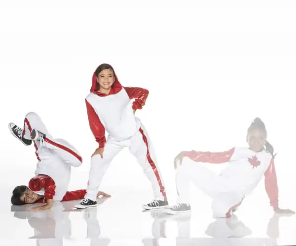 Three dancers in red and white costumes posing