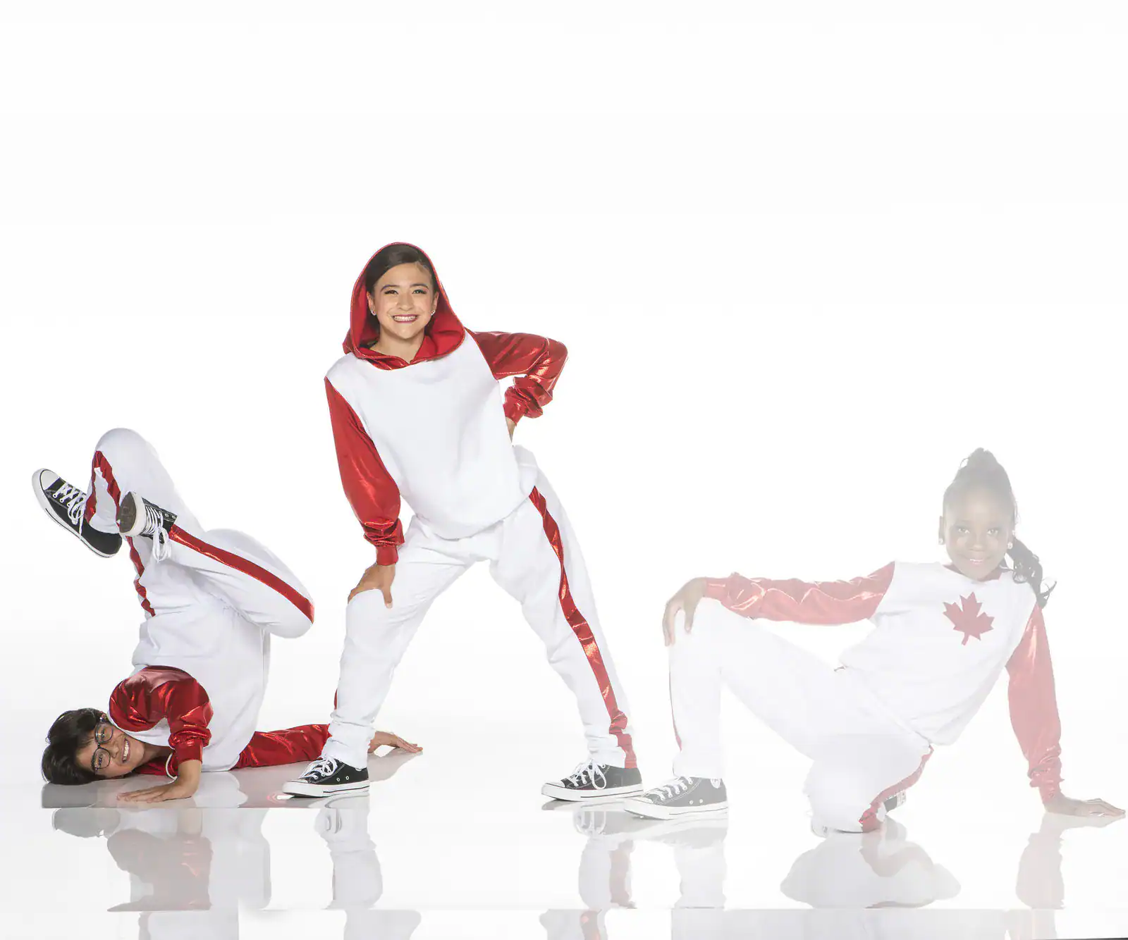 Three dancers in red and white costumes posing
