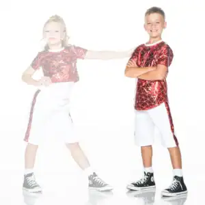 Two children wearing red metallic shirts and white shorts