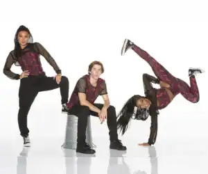 Three dancers in coordinated red and black outfits posing