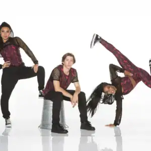 Three dancers in coordinated red and black outfits posing
